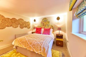 Schlafzimmer mit einem Bett mit einem großen Kopfteil in der Unterkunft Cinnabar: Luxury, Couple's Nook in Historic Walls. in Berwick-Upon-Tweed