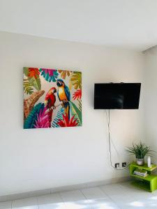 salon z obrazem dwóch ptaków na ścianie w obiekcie Superbe Studio Ultra COSY à 2 min de la PLAGE w mieście Sainte-Anne