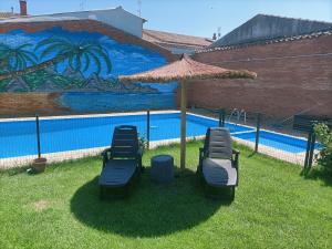 - un groupe de chaises et un parasol à côté de la piscine dans l'établissement Casa de pueblo, à Babilafuente