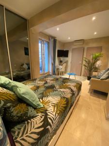 a bedroom with a large bed and a living room at La Villa Saint Jean BAS DE VILLA in La Ciotat