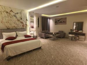 a bedroom with a large bed and a living room at آكام للشقق المخدومة أحد رفيدة in Ahad Rafidah