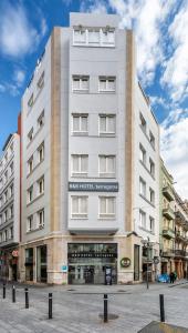 塔拉戈纳B&B HOTEL Tarragona Centro Urbis的一条城市街道上的白色大建筑
