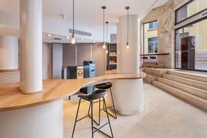 a kitchen with a bar and stools in a building at B&B HOTEL Tarragona Centro Urbis in Tarragona