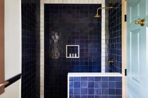 a blue tiled bathroom with a shower with blue tiles at Blue Iris by Life House in Nantucket