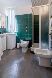 uma casa de banho com 2 WC, um chuveiro e um lavatório. em Italianway - Cavallotti 17 em Milão