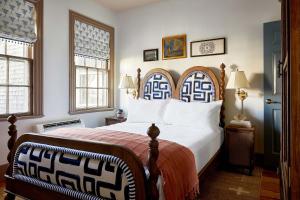 a bedroom with a large bed and two windows at Blue Iris by Life House in Nantucket