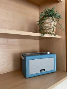 a small blue microwave sitting on a shelf with a plant at Bosuns Reach in Cockwood