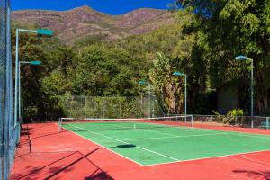 a tennis court with mountains in the background at Hotel Caminhos de Itaipava in Itaipava