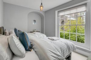 two beds in a white room with a window at Central 6 Guest City Centre Church House in Norwich