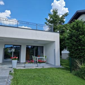 ein Haus mit einer Terrasse mit einem Tisch und Stühlen in der Unterkunft Comfy Plaza 