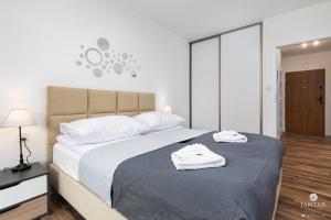 sypialnia z dużym łóżkiem i dwoma ręcznikami na nim w obiekcie Jantar Apartamenty- Wyspa Solna w Kołobrzegu
