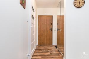 korytarz z drzwiami i zegarem na ścianie w obiekcie Jantar Apartamenty- Wyspa Solna w Kołobrzegu +15 zdjęć