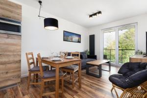 jadalnia i salon ze stołem i krzesłami w obiekcie Jantar Apartamenty- Wyspa Solna w Kołobrzegu