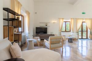 a living room with a couch and chairs and a table at Hotel Brancamaria in Cala Gonone