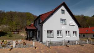 a large white house with a black roof at Pension Edelstein in Ostseebad Sellin