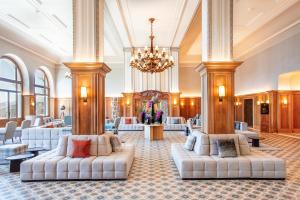 a lobby with two white couches and a chandelier at Villars Palace in Villars-sur-Ollon