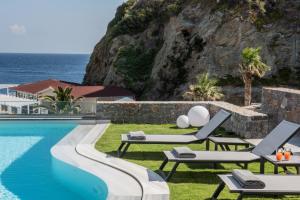 un complejo con una piscina con sillas y el océano en Made By The Sea Villa 4, en Ligaria