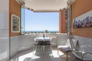 a balcony with a table and chairs and a view of the ocean at Marina view apartment in Fuengirola