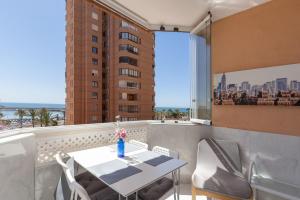 a balcony with a table and chairs and a window at Marina view apartment in Fuengirola