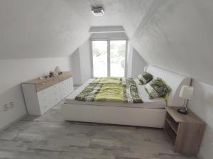 Habitación blanca con cama y ventana en Farářova vyhlídka, en Náchod