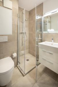 een badkamer met een douche, een toilet en een wastafel bij Friesenhuus Friesenhuus Norderney, Whg 02 in Norderney