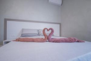 Dwa różowe flamingi siedzące na łóżku w obiekcie B&B "La Vista Preziosa" Feeling Home w mieście Gallipoli