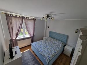 een kleine slaapkamer met een blauw bed en een raam bij D&Y Apartments in Piatra Neamţ