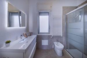 a white bathroom with a sink and a toilet at B&B "La Vista Preziosa" Rooms in Gallipoli