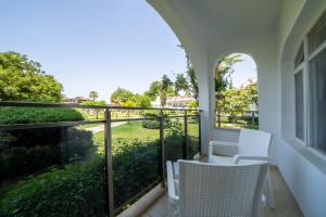 a balcony with white chairs and a view of a yard at Lykia Botanika Beach Fun & Club - All Inclusive in Fethiye