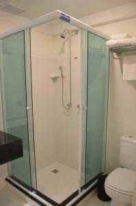 a glass shower in a bathroom with a toilet at Prix Hotel in Passo Fundo