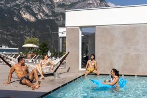 Aris Apartments & Sky Pool - TonelliHotels في ريفا ديل غاردا: مجموعة من الناس يجلسون في مسبح