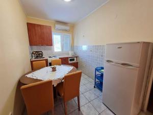 a small kitchen with a table and a refrigerator at Apartments in Mundanije/Insel Rab 30445 in Mundanije
