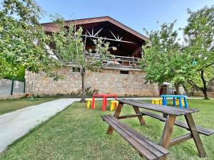 Turnaboğazı Çiftlik Evleri في إزمير: طاولة نزهة مع طاولات ملونة في الحديقة