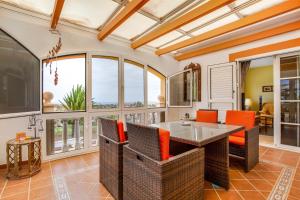 a living room with a table and chairs and windows at Fuerteventura Relax and Sea in Antigua