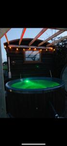 una gran piscina verde con luces en la parte superior. en Four seasons small holding en Hereford