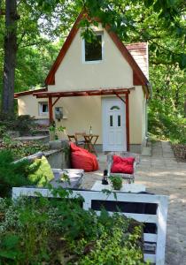 Casa pequeña con almohadas rojas en el patio en Vércse Vendégház en Kismaros