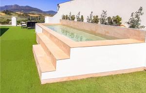 una piscina en un patio trasero con césped verde en Beautiful Home In Montecorto With Kitchen, en Montecorto