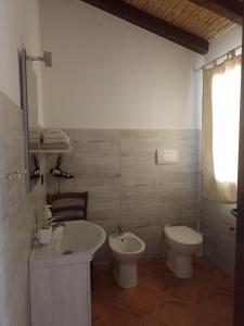 uma casa de banho com um lavatório e um WC em Tenuta Don Ballore em Galtellì