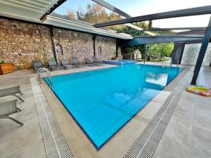 a swimming pool with blue water in a house at Turnaboğazı Çiftlik Evleri in Izmir