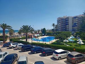 a parking lot with cars parked next to a pool at Apartamento Ciudamar in Puerto de Sagunto