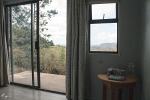 Cette chambre dispose d'une grande fenêtre donnant sur une terrasse couverte. dans l'établissement Ollivanders Estate, à KwaNgendezi