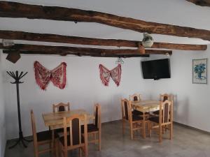 a dining room with wooden tables and butterflies on the wall at Borlova /Muntele Mic in Borlova