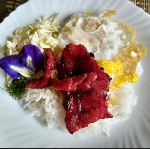 a plate of food with rice and flowers on it at Casa De Cortijo Family Room in Pagbilao