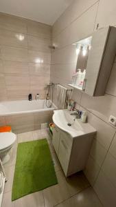 baño con lavabo blanco y alfombra verde en Central Quick, private parking, en Cluj-Napoca