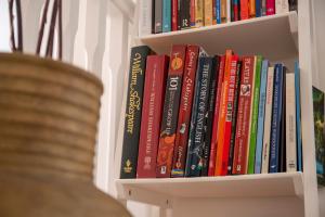 a book shelf filled with lots of books at Beautiful 2-Bedroom Townhouse in Stratford upon Avon in Stratford-upon-Avon
