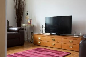 a living room with a flat screen tv on a dresser at Beautiful 2-Bedroom Townhouse in Stratford upon Avon in Stratford-upon-Avon