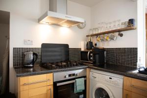cocina con fogones horno superior junto a una lavadora en Central Townhouse in Stratford upon Avon en Stratford-upon-Avon