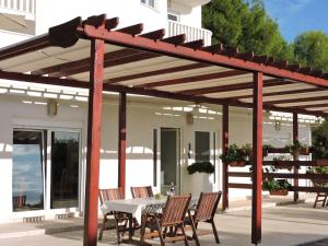 a wooden pergola on a patio with a table and chairs at Villa Bianca in Trogir