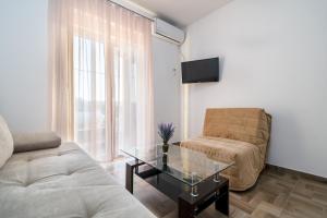 Una sala de estar con un sofá y una mesa de cristal. en Apartments Glorija, en Neum