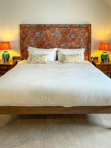 a bedroom with a large white bed with two lamps at Parador 44 in Cardiff